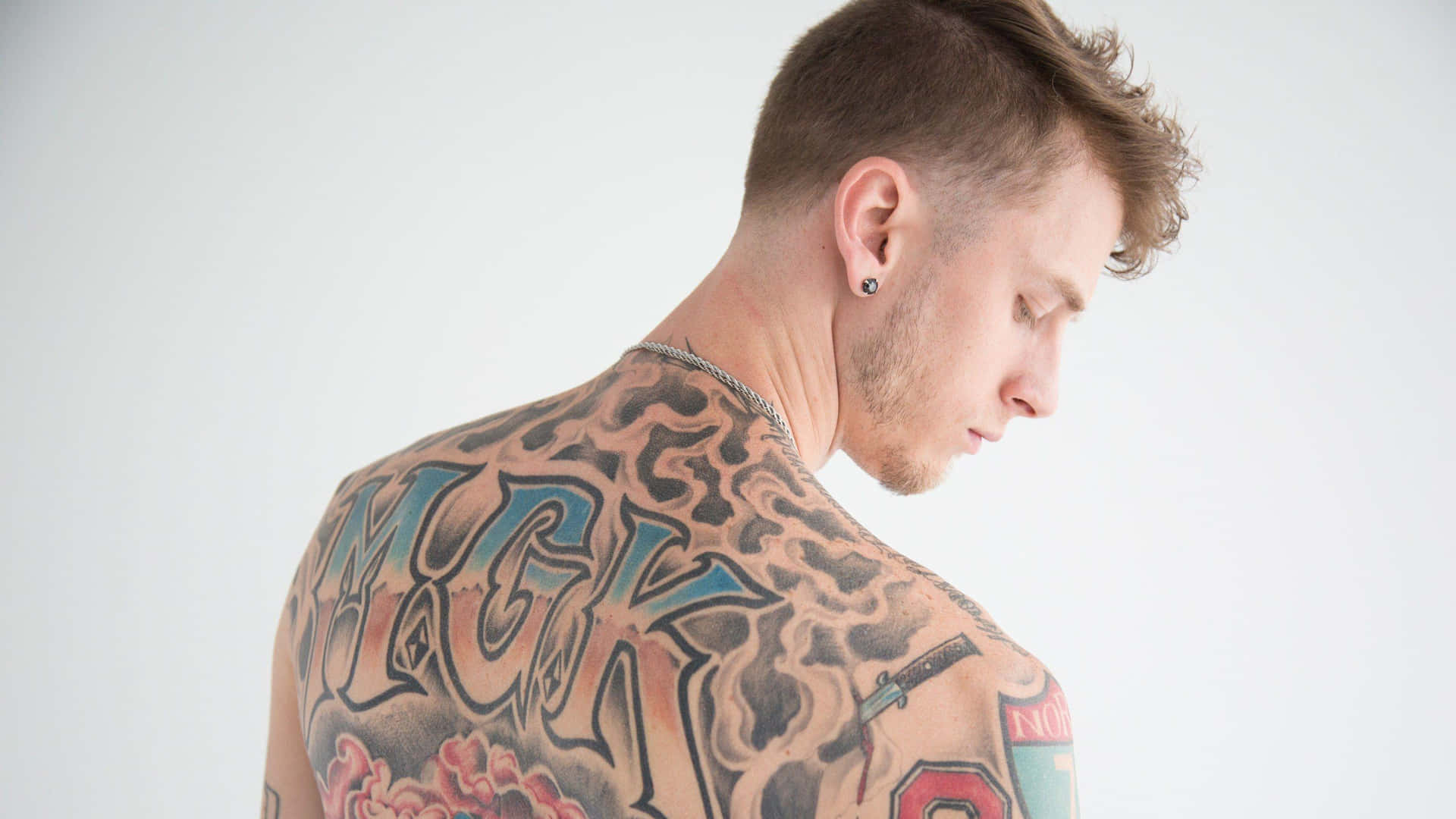 Mgk Showing His Back Background