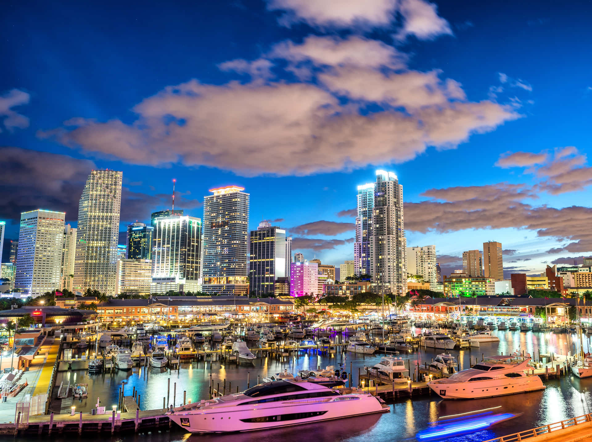 Miami City Skyline At Night With Boats Docked Background