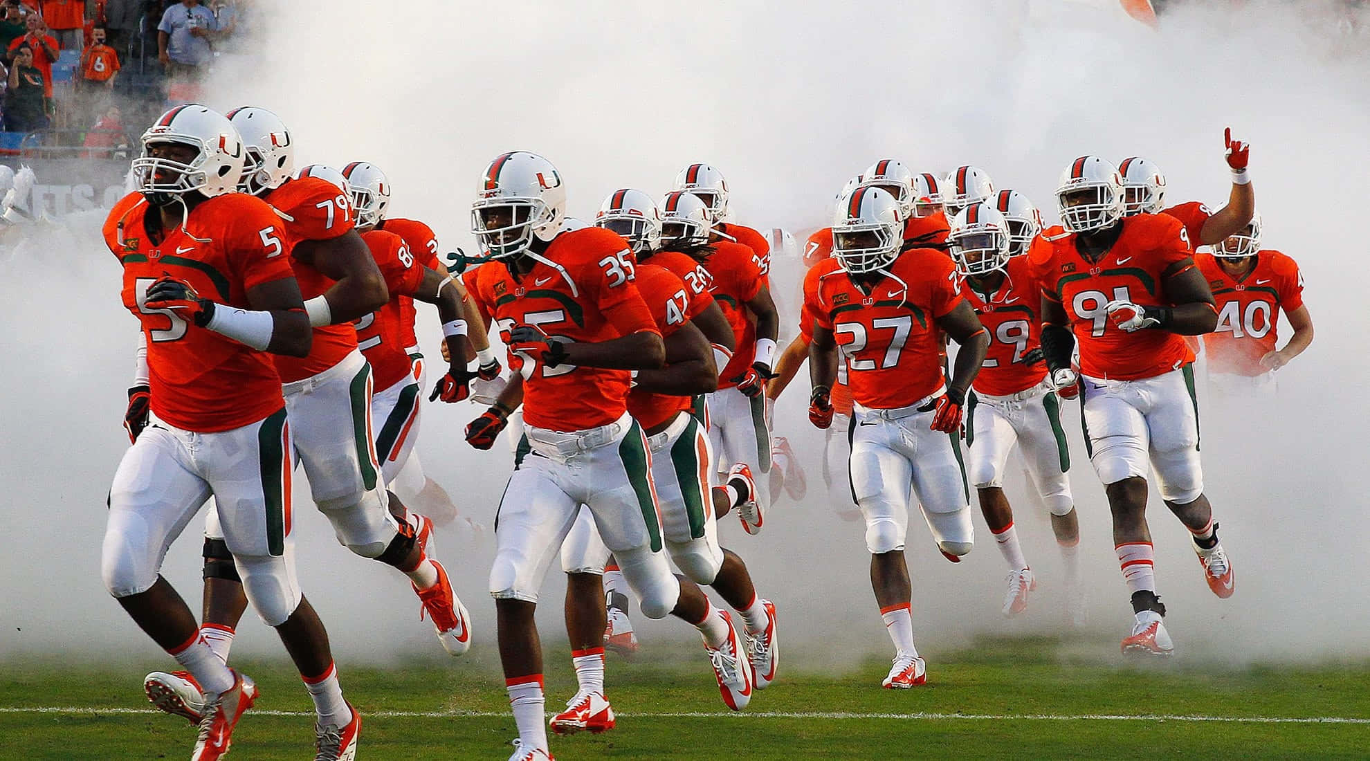 Miami Hurricanes Players On Field Background