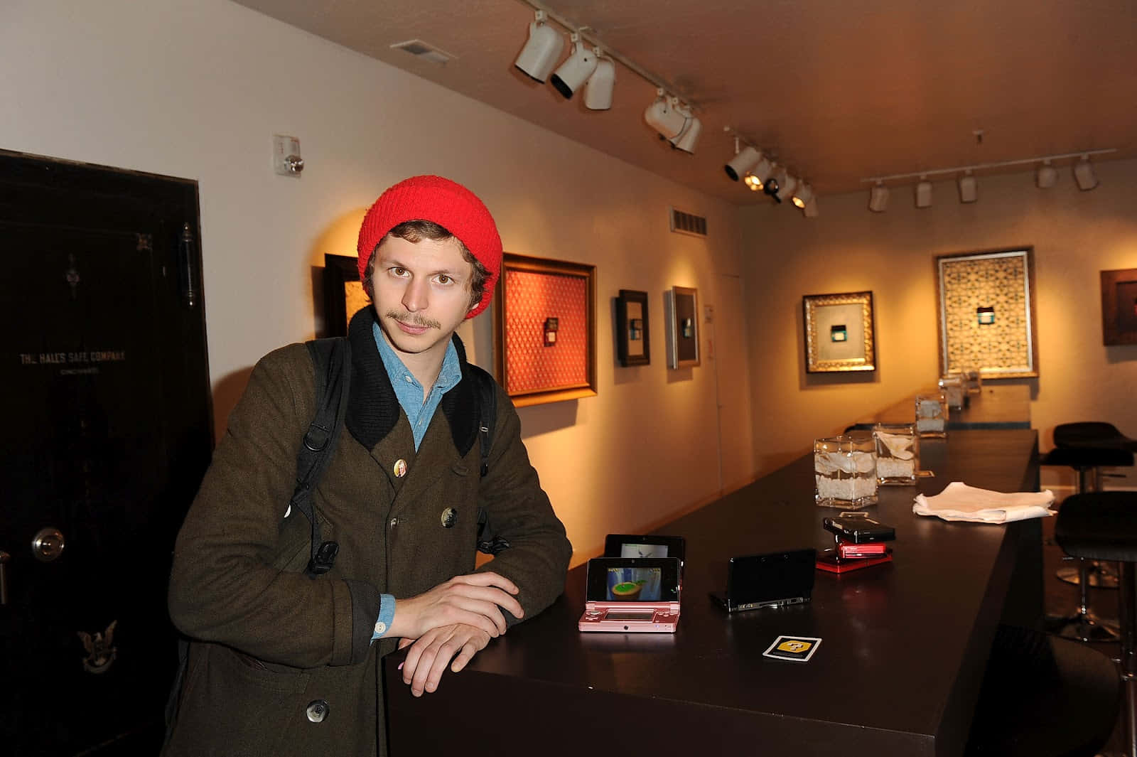 Michael Cera Smiling Against A Blue Backdrop Background