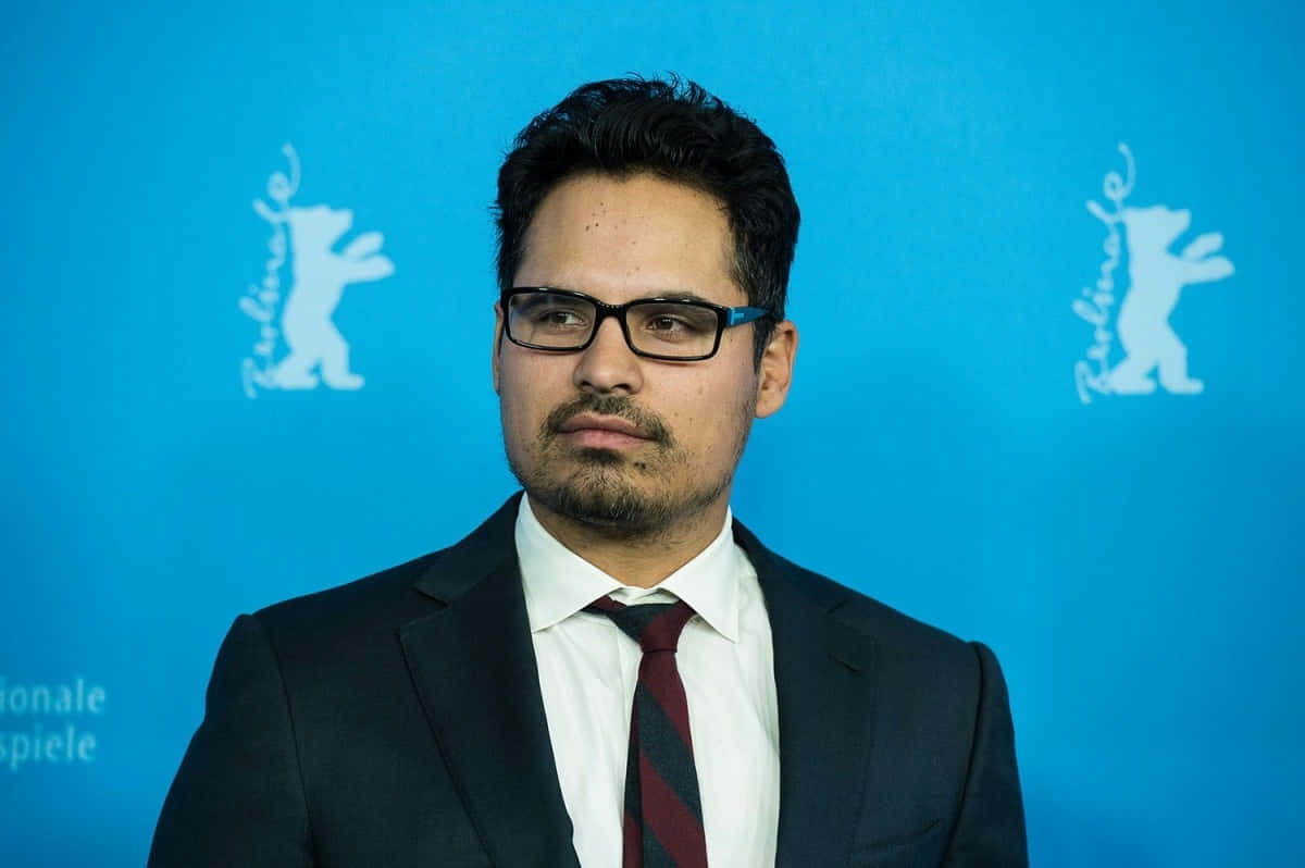 Michael Peña Smiles Graciously In The Frame Background