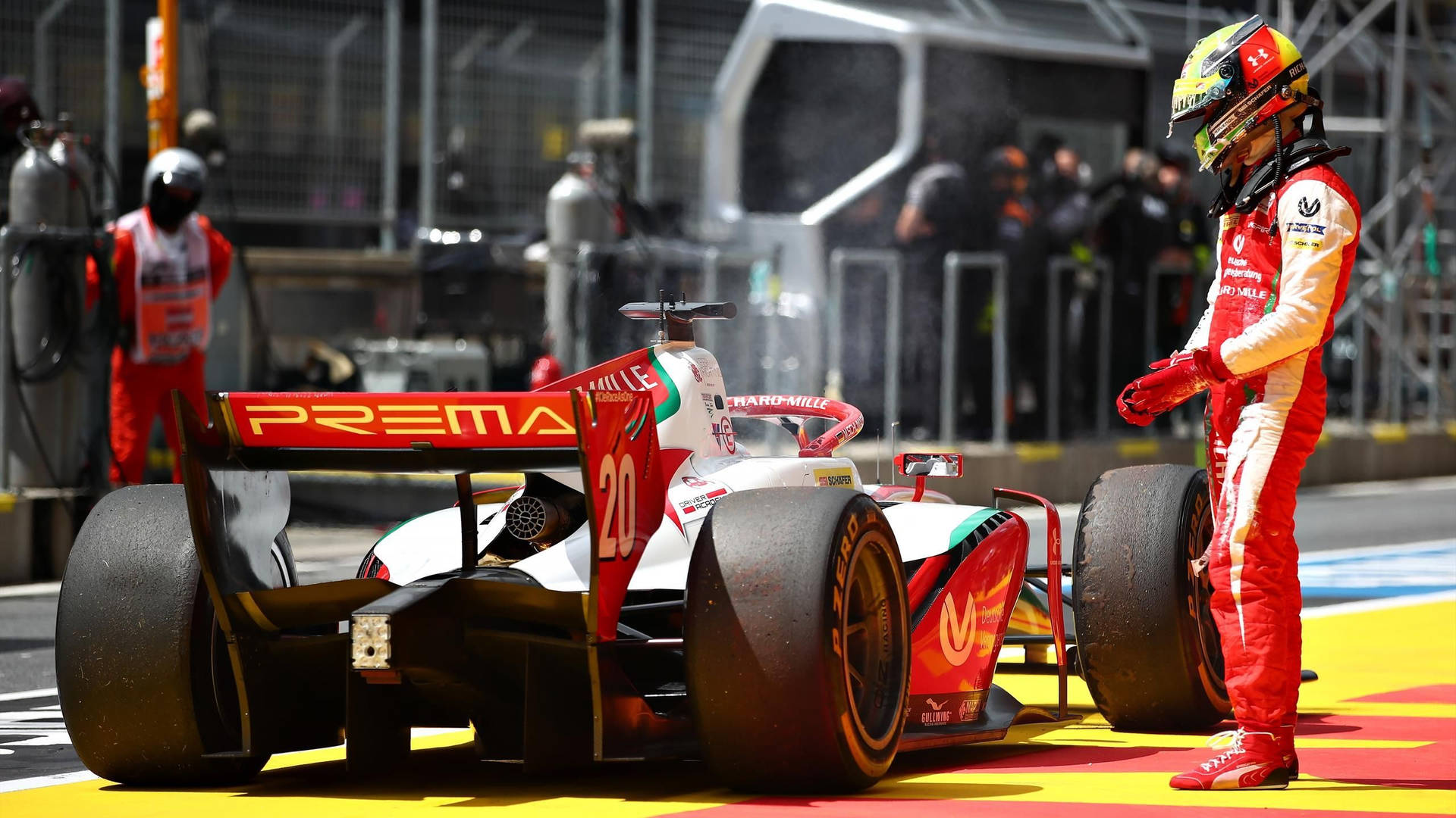 Mick Schumacher Beside A Race Car Background