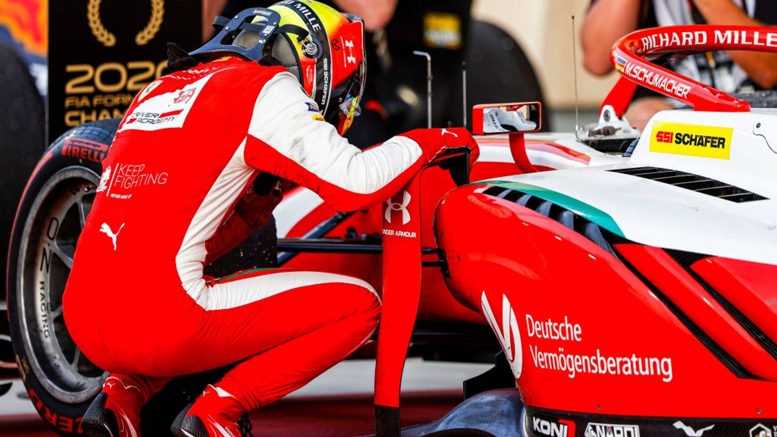 Mick Schumacher Crouched Over A Car