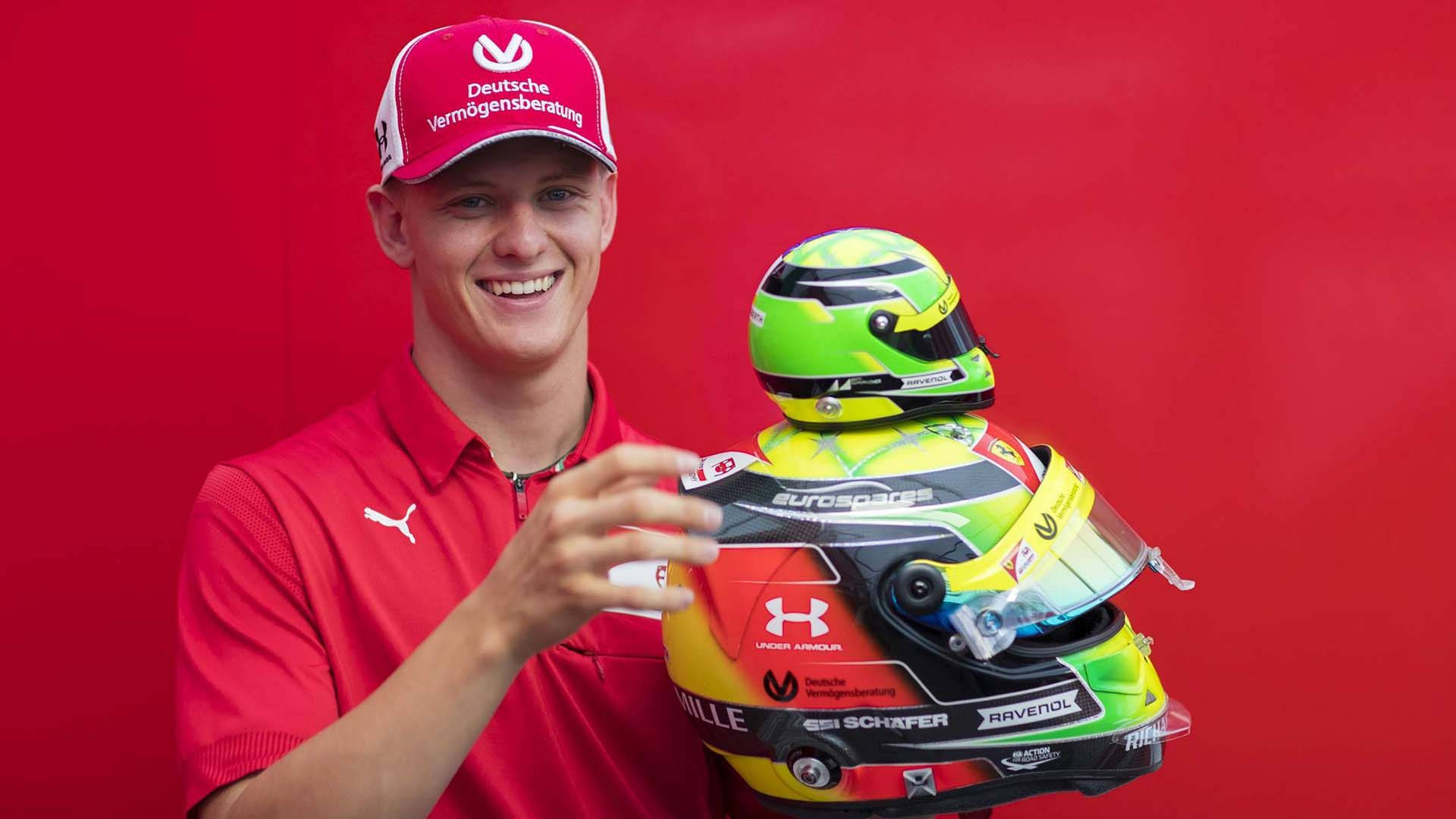 Mick Schumacher Holding Miniature Helmet Background