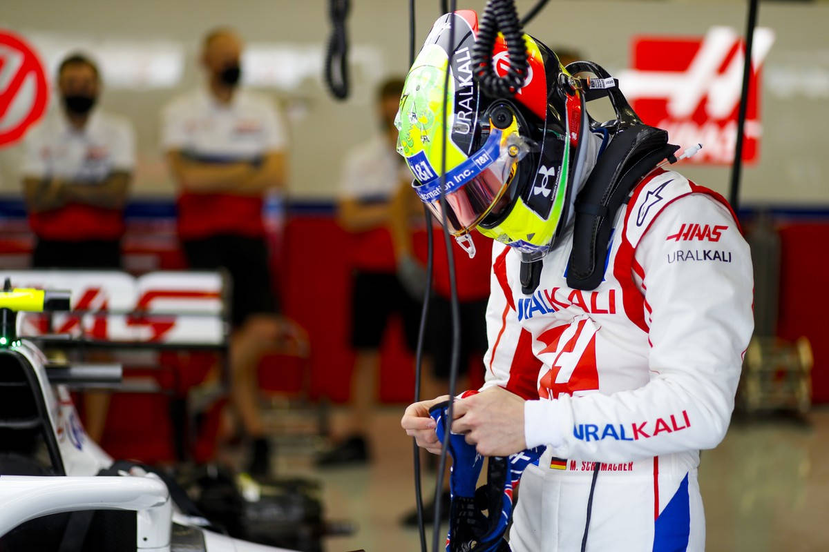 Mick Schumacher In Helmet And Suit Background