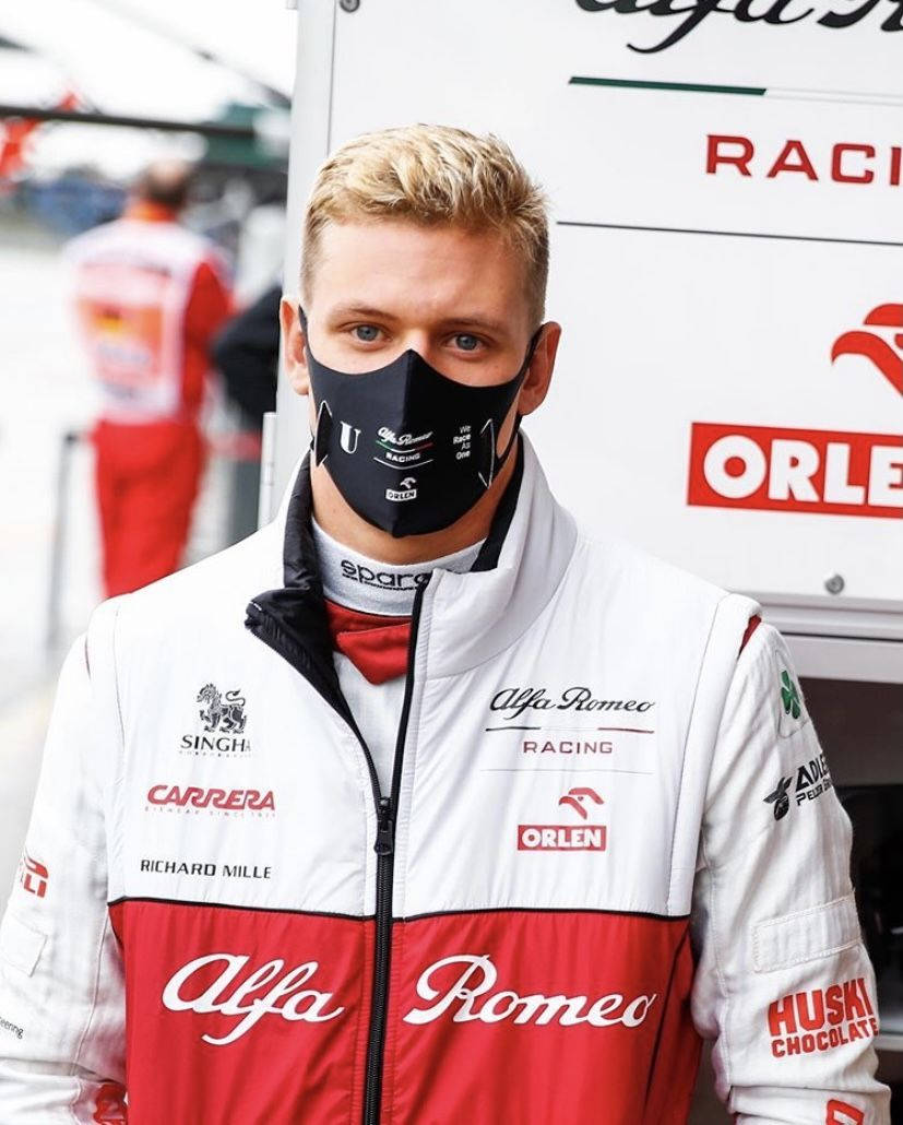 Mick Schumacher In Jacket And Mask Background