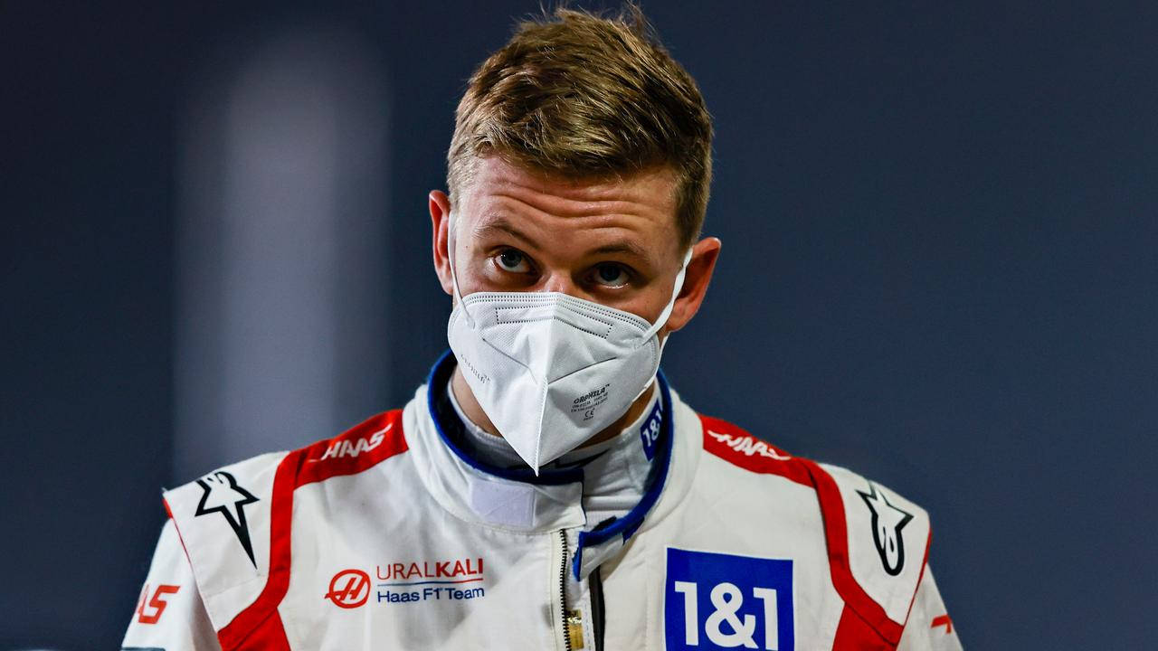 Mick Schumacher Preparing For A Race In A Protective White Mask.