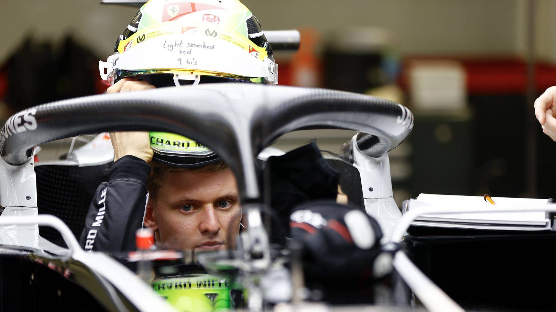 Mick Schumacher Suiting Up For The Race Background