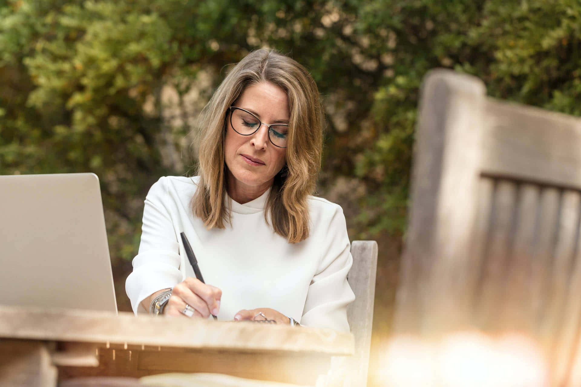 Middle Aged Woman Writing Outdoors Background