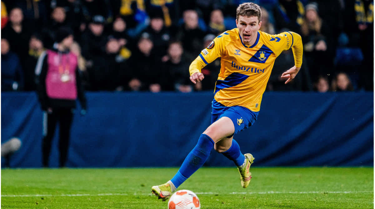 Mikael Uhre In Action During Match Background