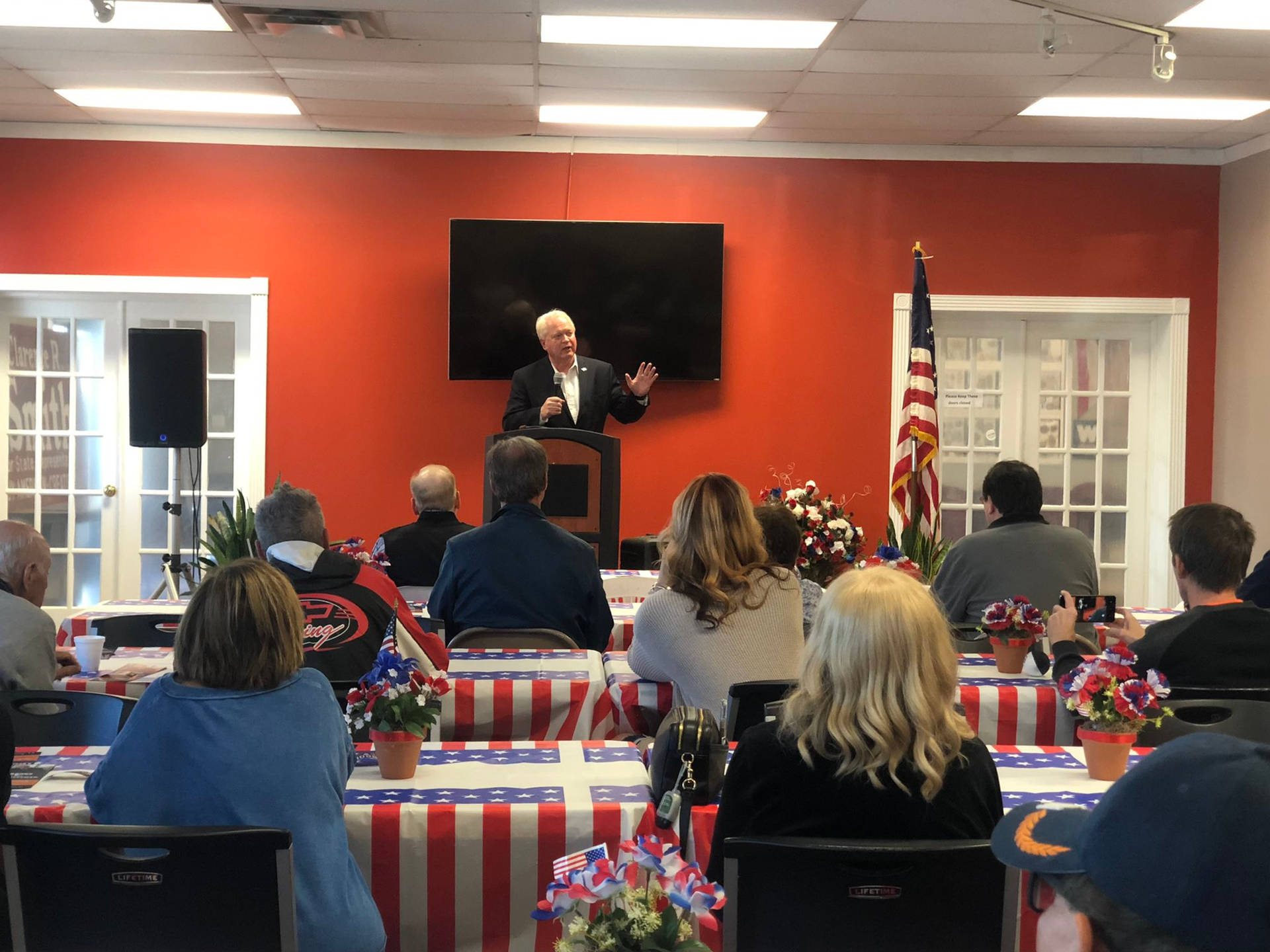 Mike Gibbons In Conference With Flag-like Tables