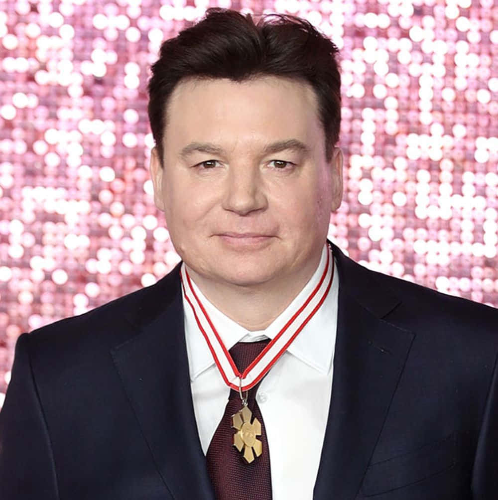 Mike Myers Looking Confident Against An Orange Background Background
