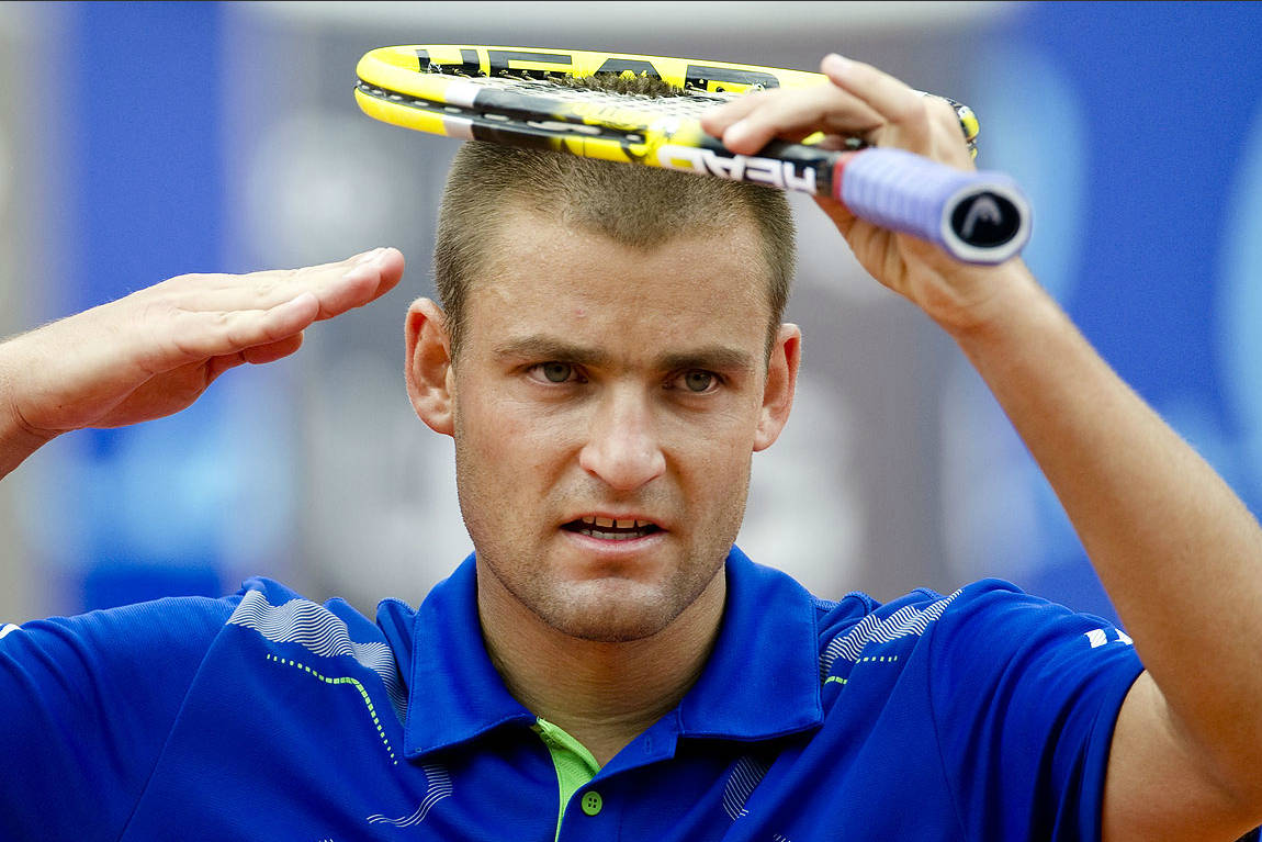 Mikhail Youzhny Doing His Signature Salute On A Tennis Court.