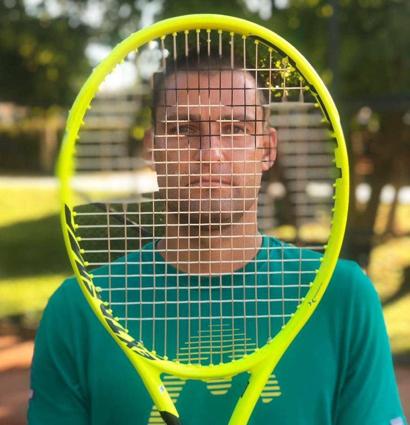 Mikhail Youzhny Face Behind Tennis Racket Background