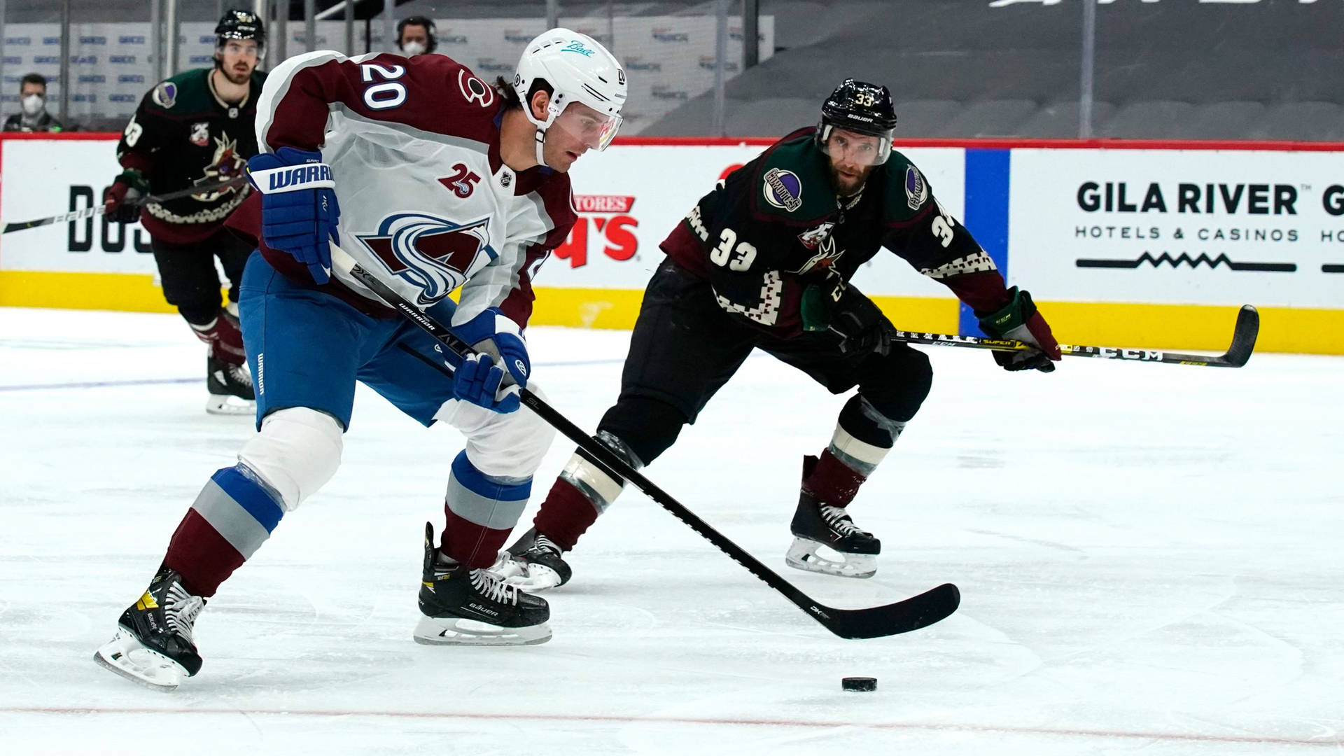 Mikko Rantanen Dribbling Hockey Puck Against Rival Players Background