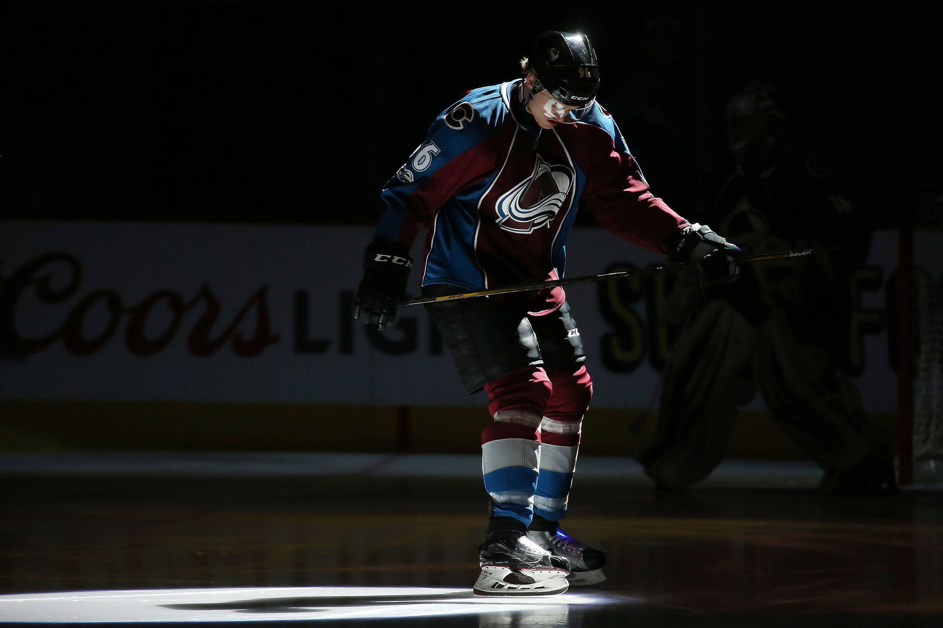Mikko Rantanen Holding Hockey Stick Under Spotlight Background