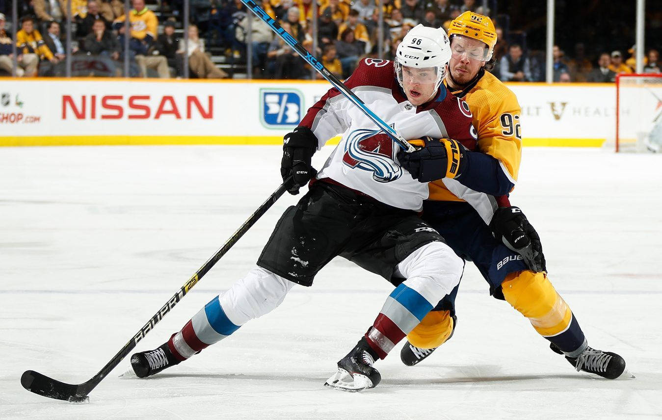 Mikko Rantanen Leaning And Falling Against Player From Nashville Predators Background