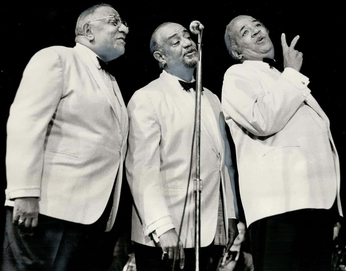 Mills Brothers Performingin White Tuxedos Background