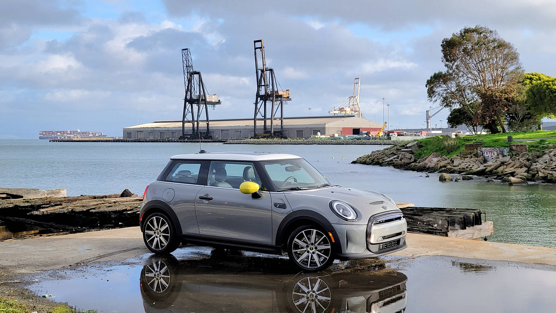 Mini White Car By Ocean Side Background