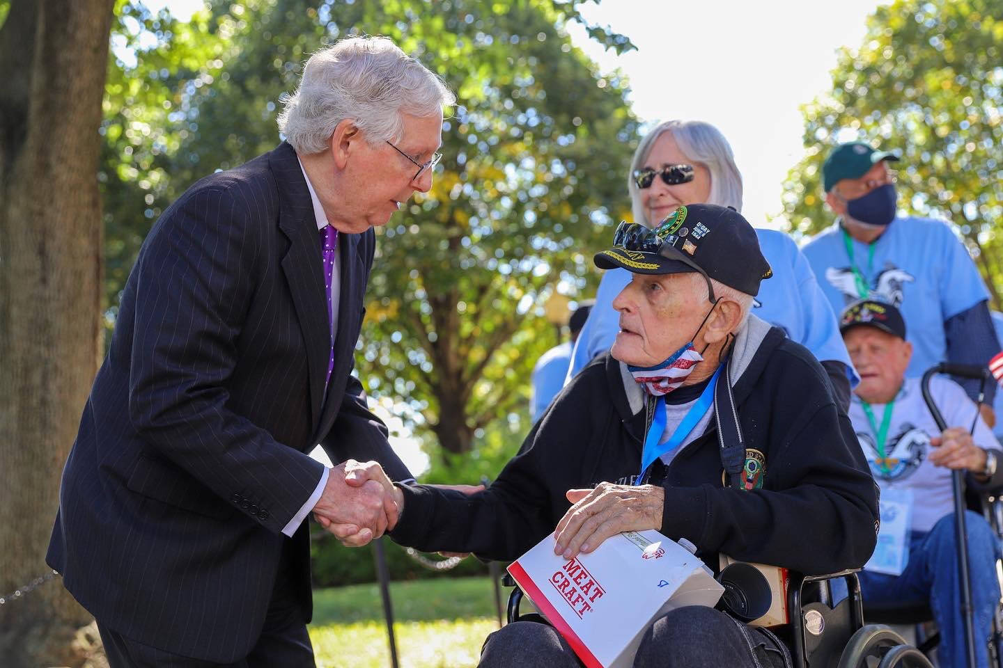 Mitch Mcconnell Assisting Elderly Man In Wheelchair Background