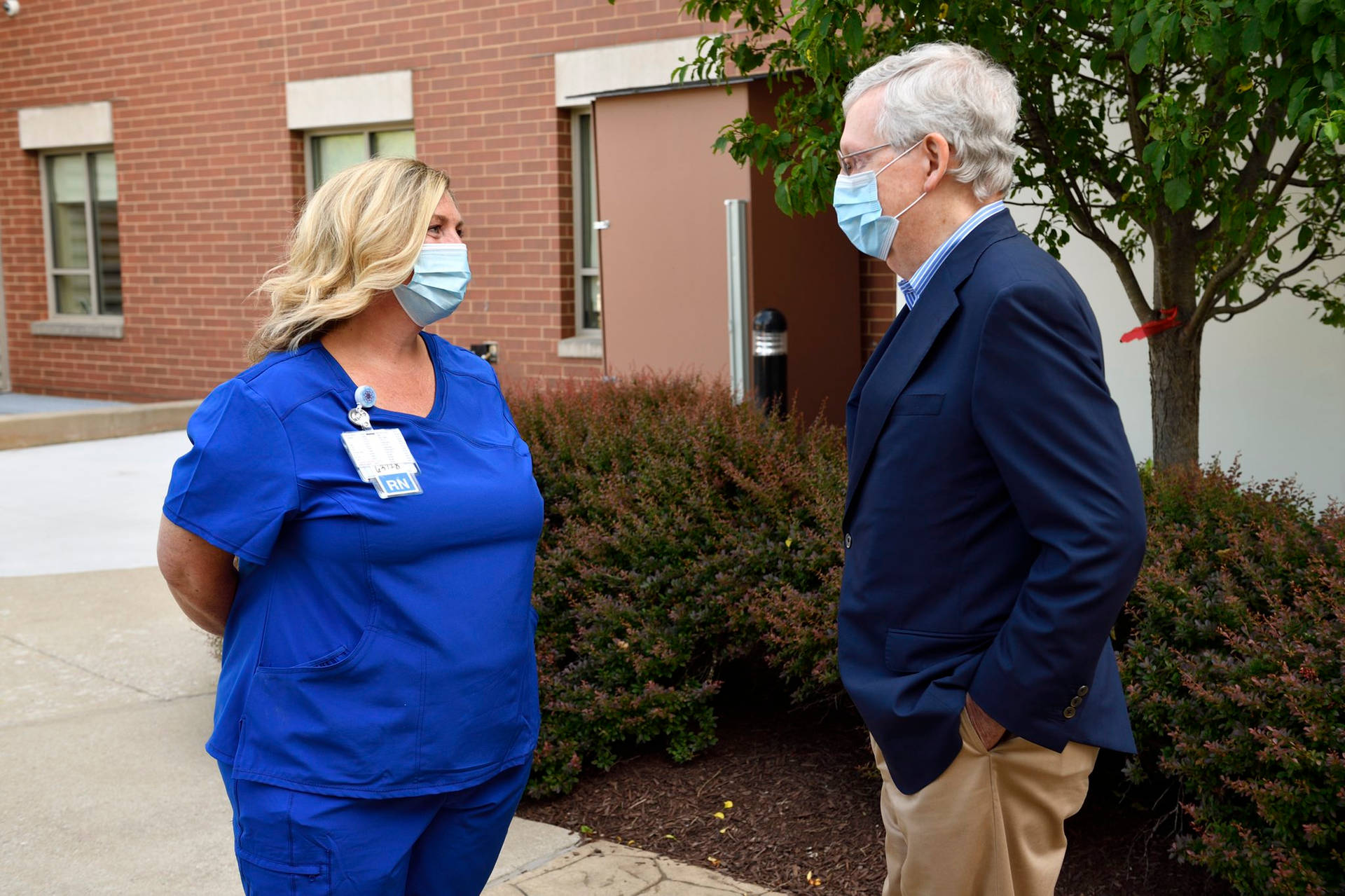 Mitch Mcconnell Engaged In Conversation With A Healthcare Professional Background