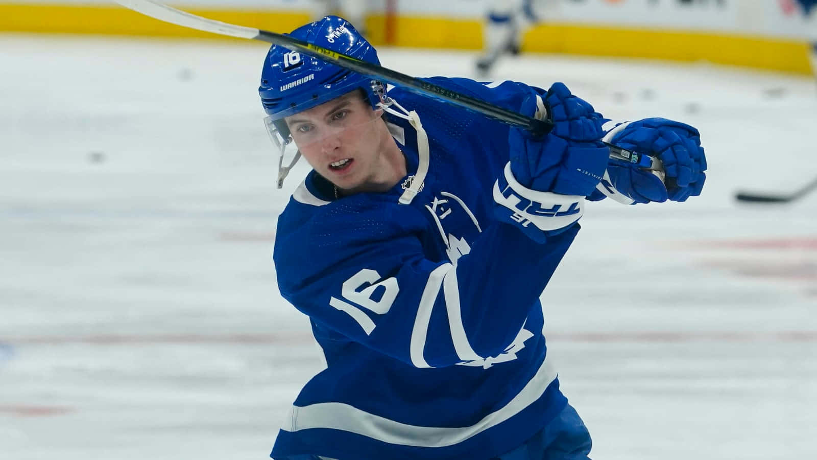 Mitchell Marner Hitting A Puck Background