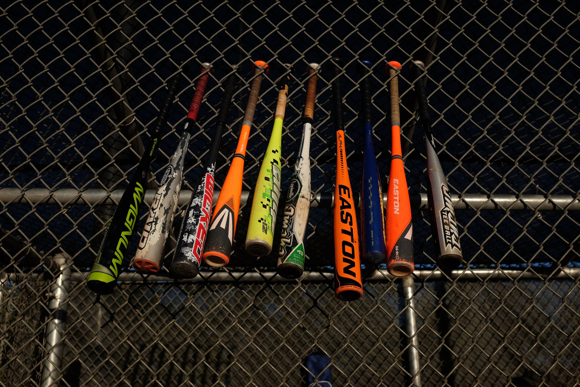 Mlb Bats Hung At Field Fence Background