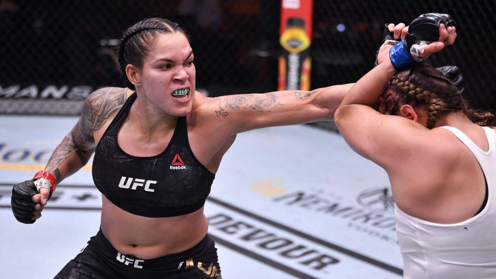 Mma Fighter Amanda Nunes Unleashing A Punch Background