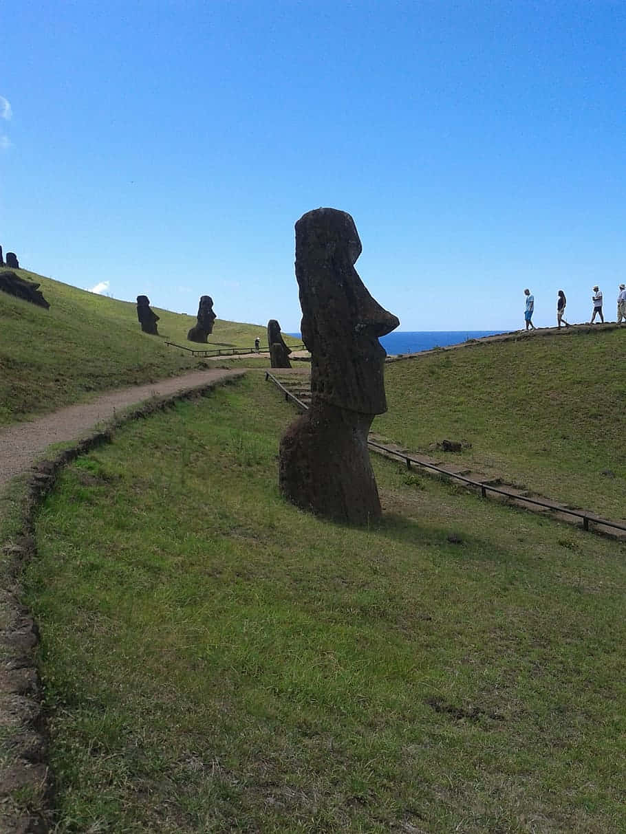 Moai Figures With Tourists Background