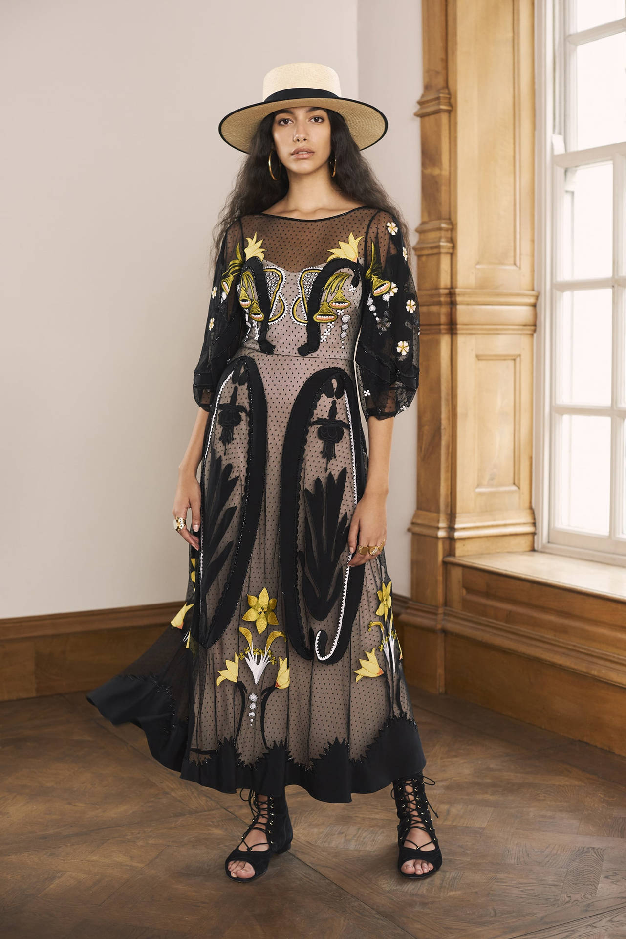 Model Portraying Timeless Fashion In A Temperley London Black Dress With White Hat Background