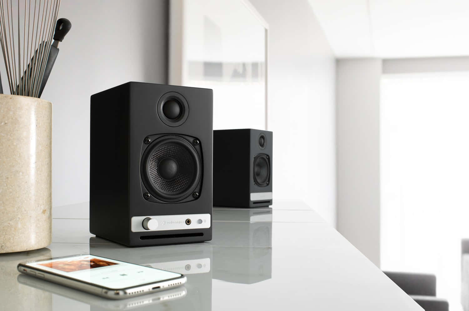 Modern Wireless Speakers Paired With White Smartphone Background