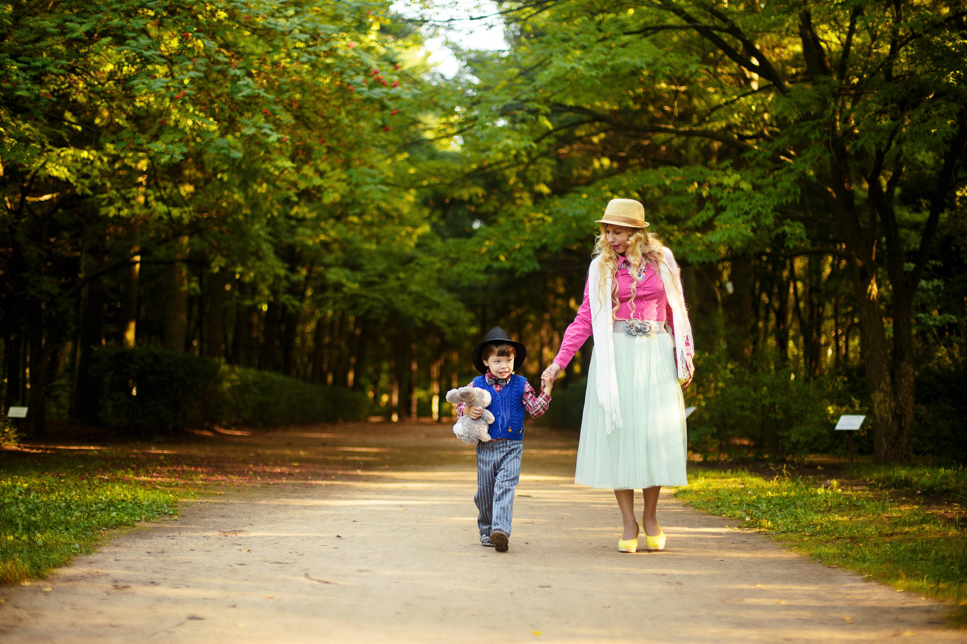 Mom And Son Holding Hands In Park Background