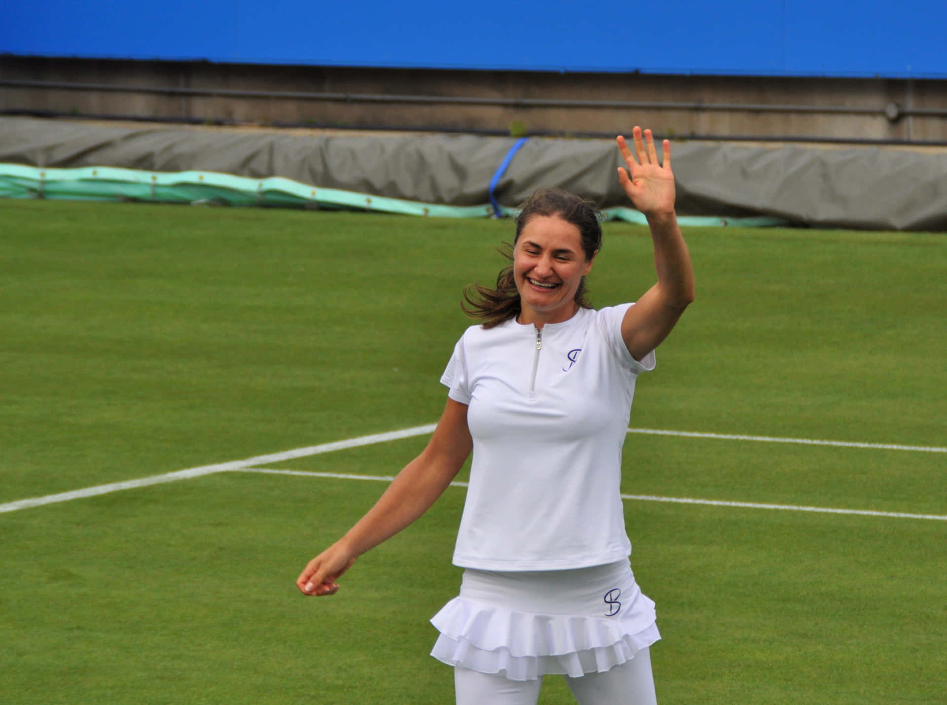 Monica Niculescu Smiling And Waving To Her Audience Background