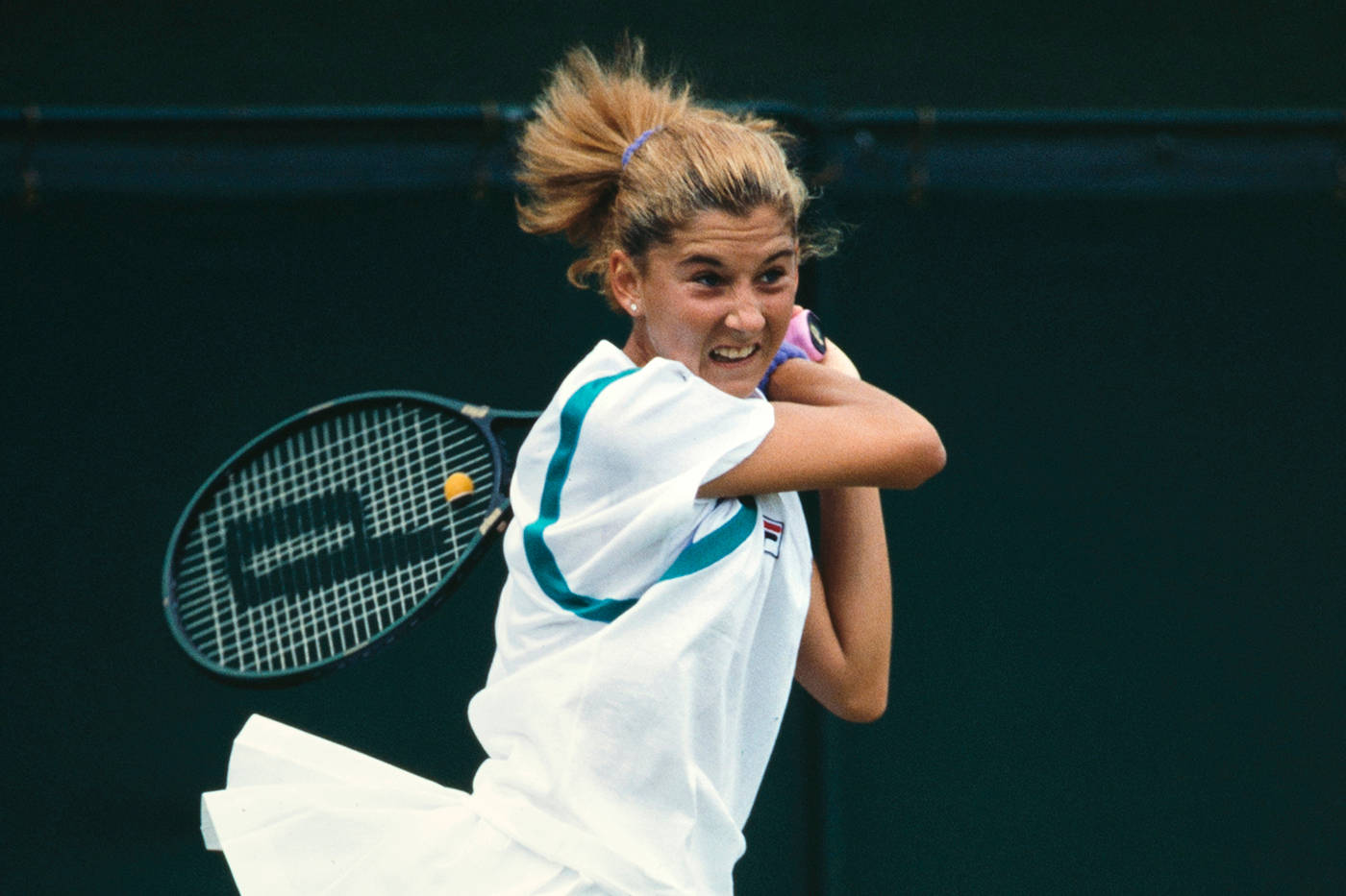 Monica Seles Holding Racket Over Shoulder Background