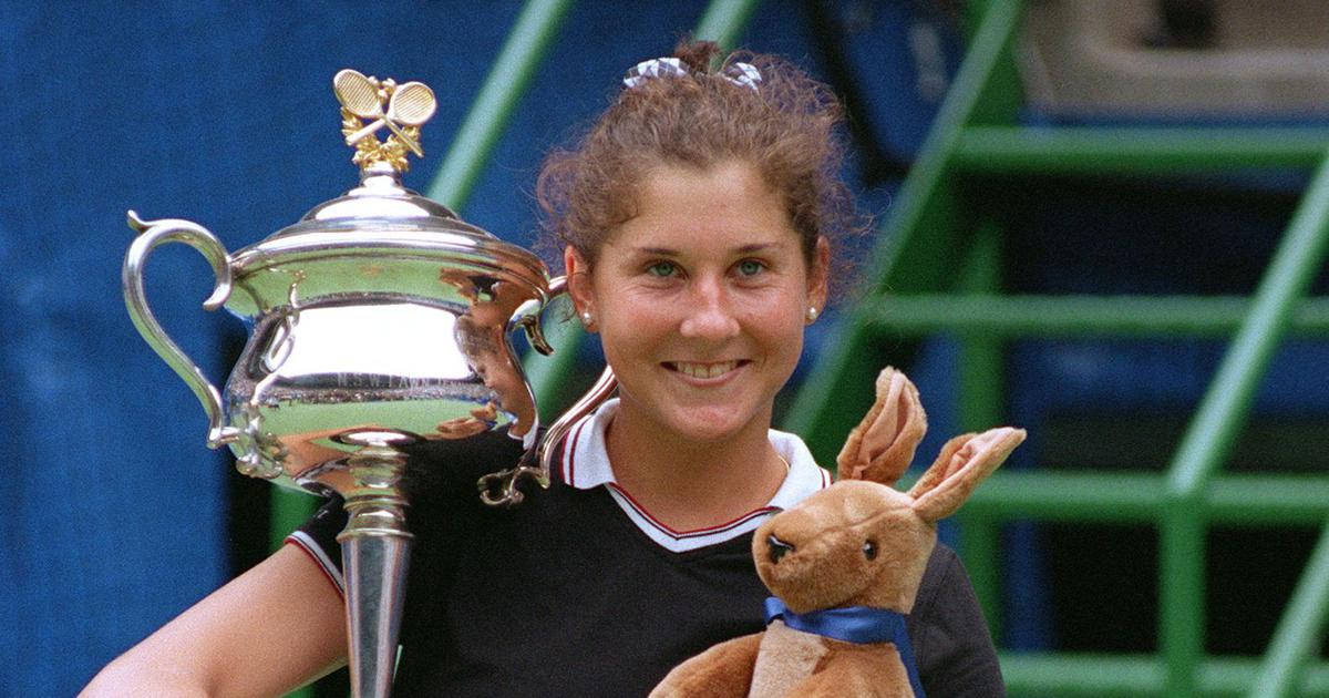 Monica Seles Holding Trophy And Toy Background