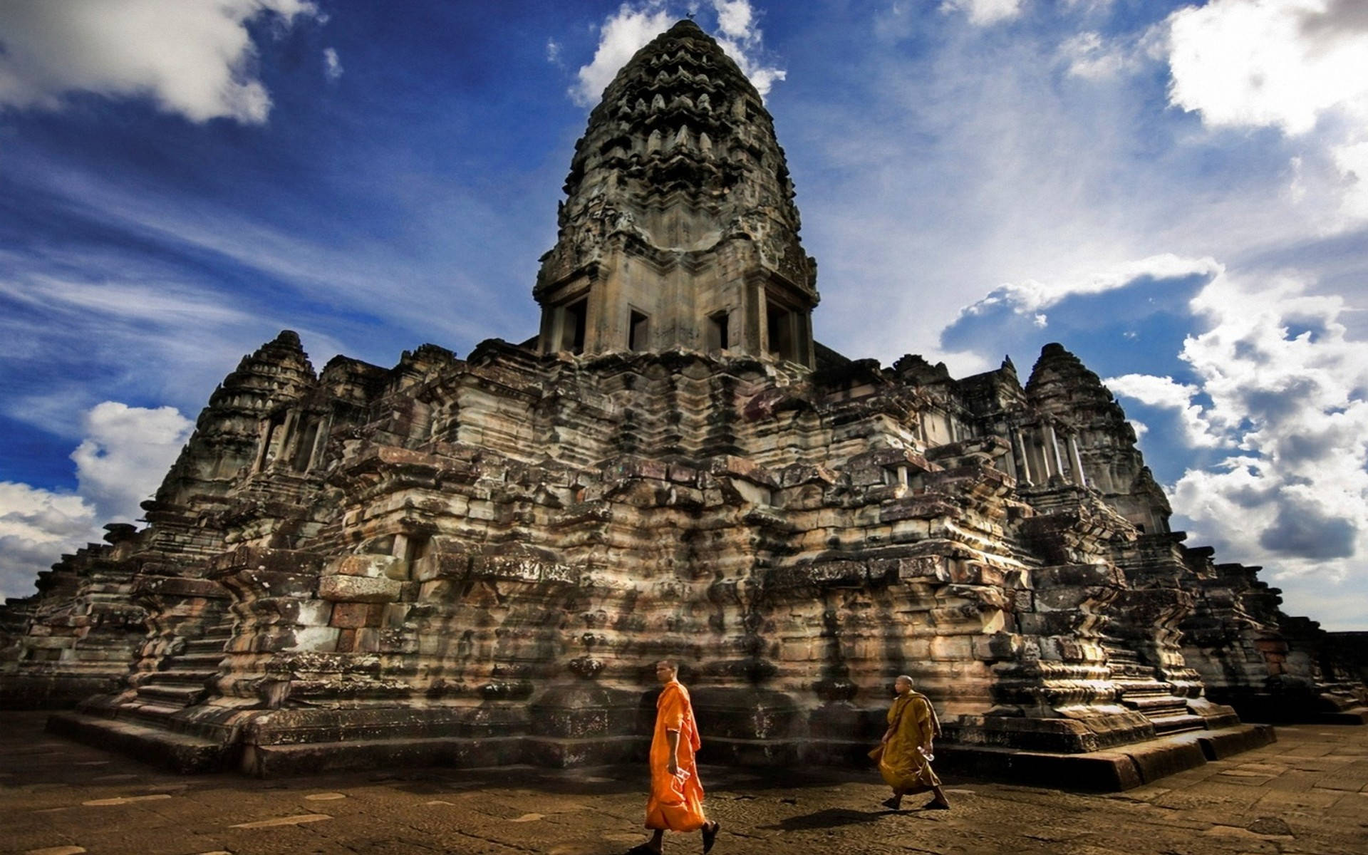 Monks Walking By Ruins Of Angkor Wat Background
