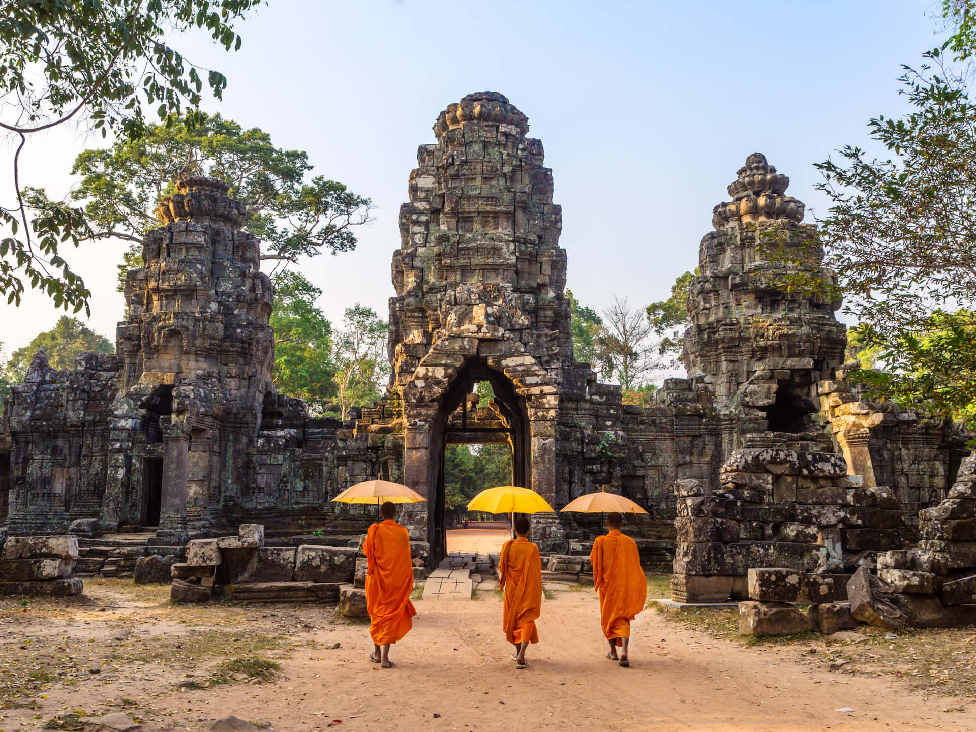 Monks With Umbrellas Entering Angkor Thom Background