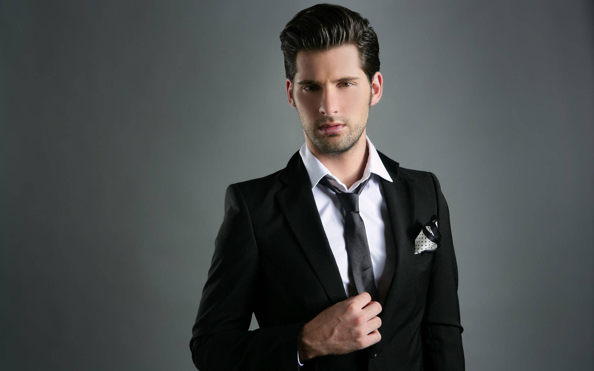 Monochrome Elegance: Portrait Of A Handsome Man In Suit Background