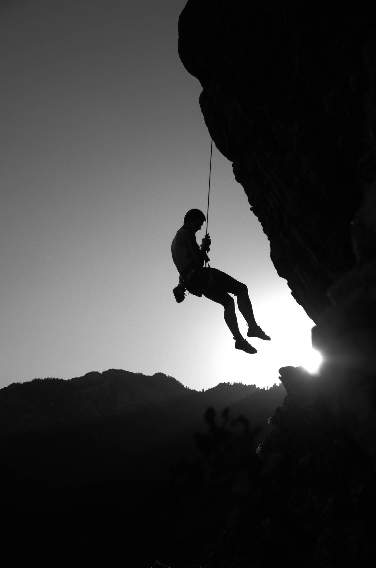 Monochrome Photo Of Man Rock Climbing Background