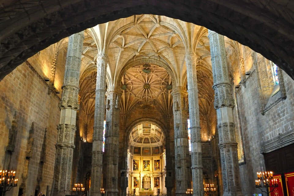 Mosteiro Dos Jeronimos From An Archway Background