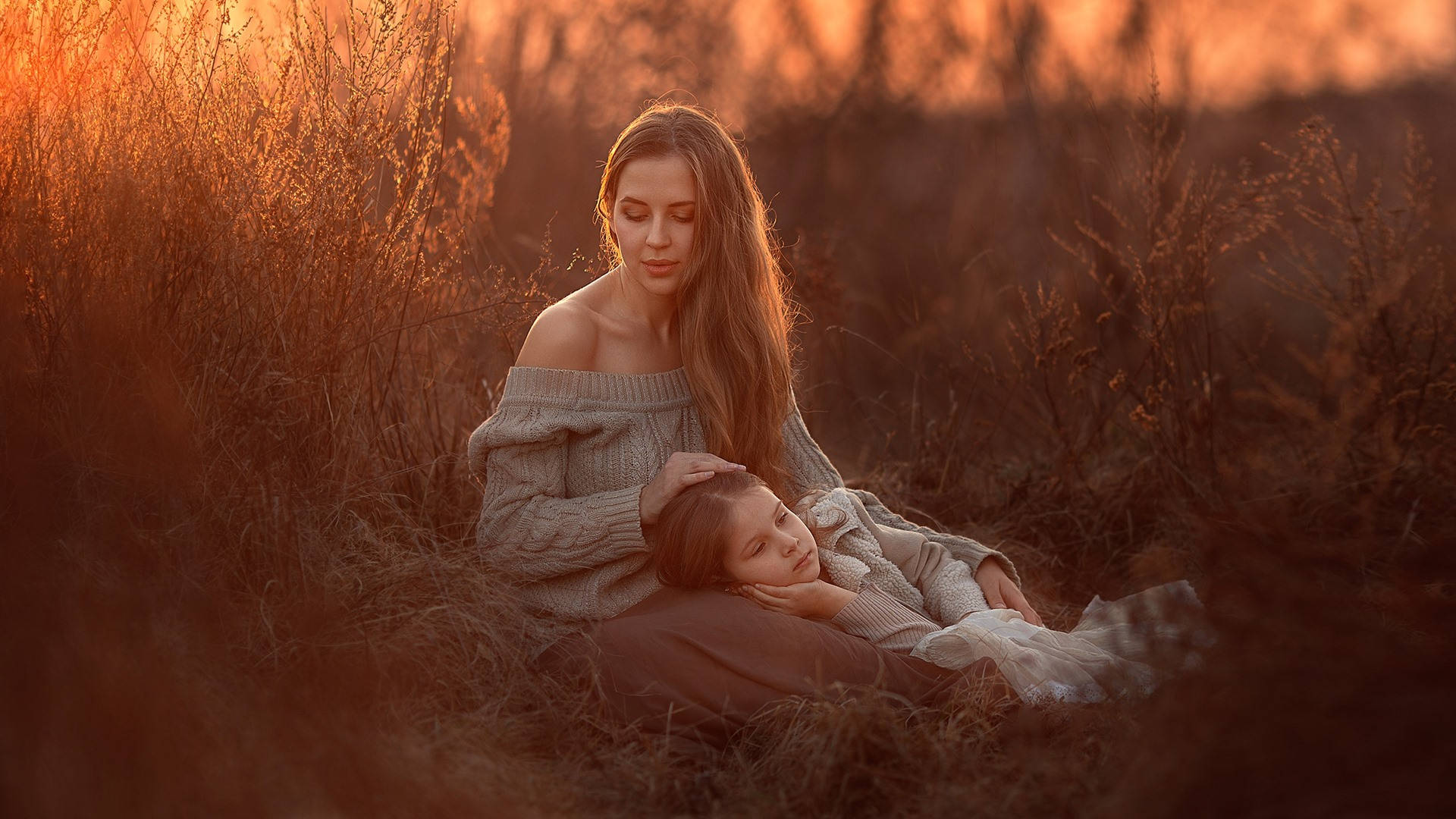 Mother And Daughter Resting On A Field Background