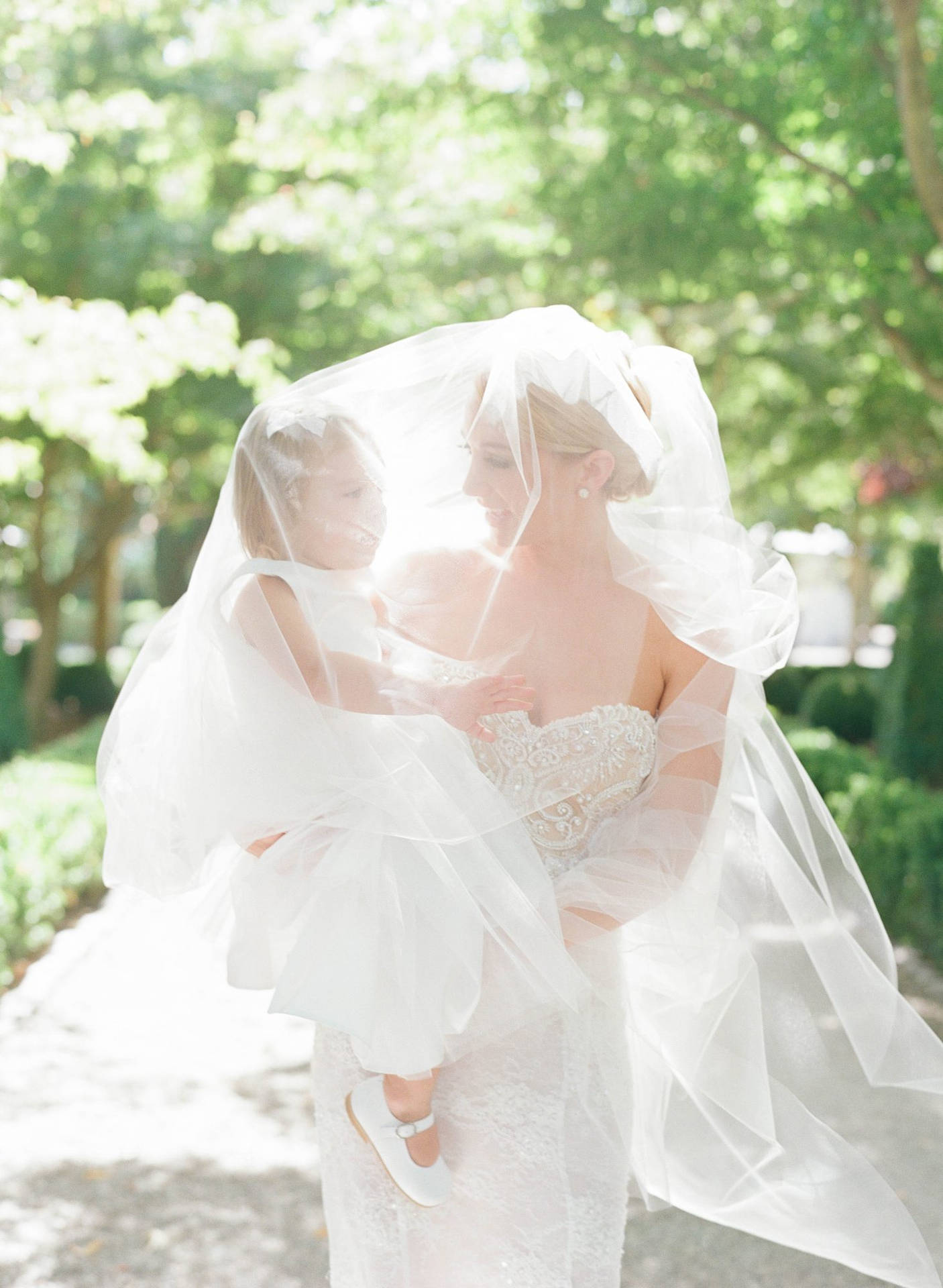 Mother And Daughter Under A Veil Background