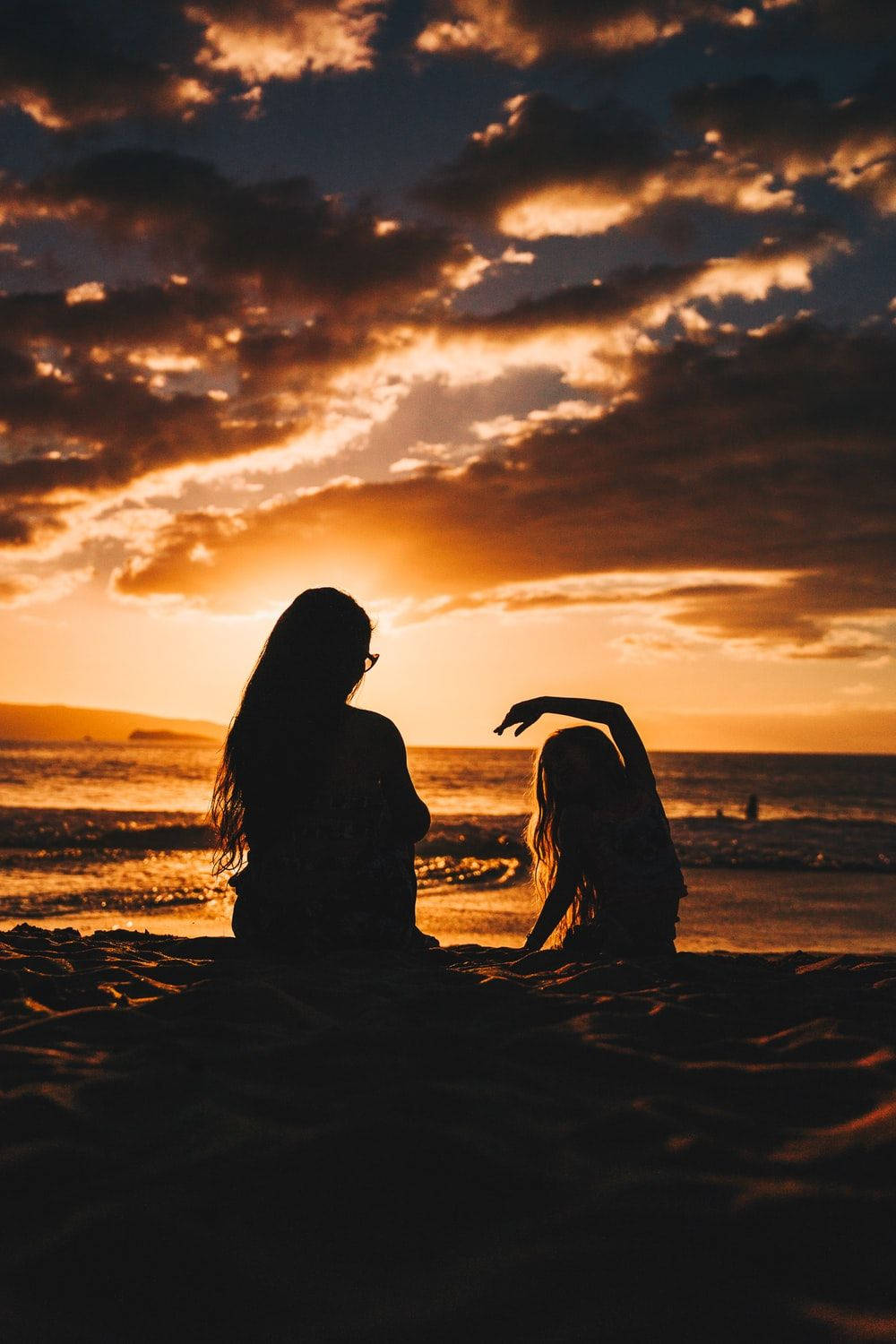 Mother And Daughter Watching Beach Sunset Background