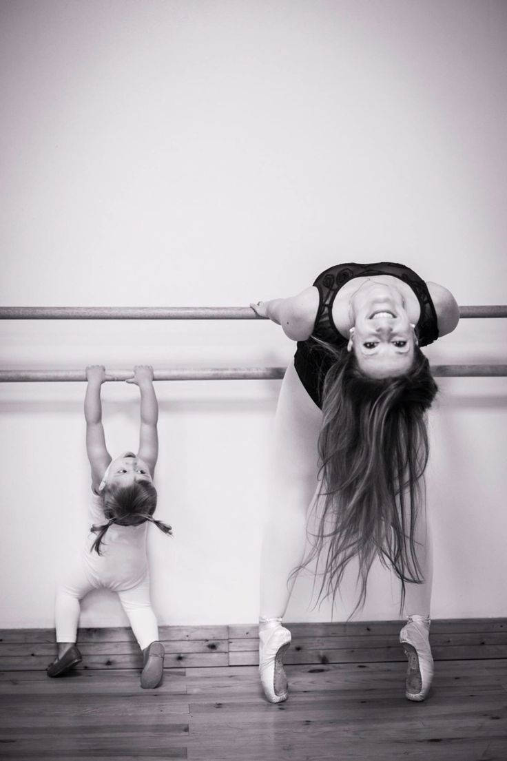 Mother Helping Her Daughter Workout At The Ballet Barre Background