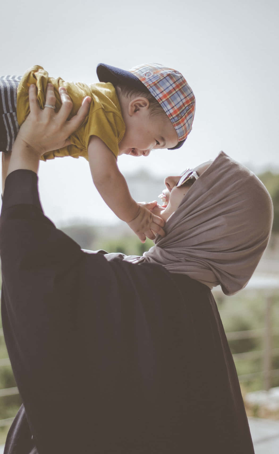 Mother Lifting Muslim Boy Background