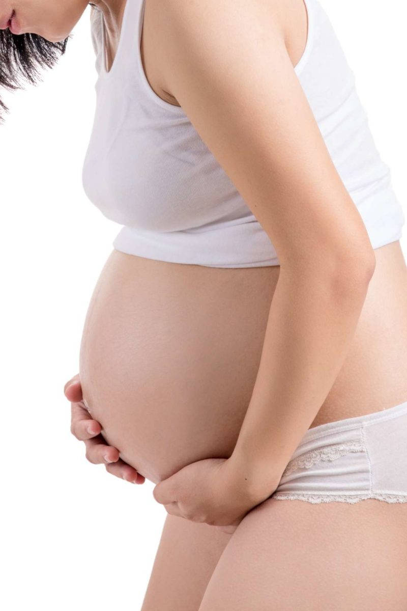 Mother's Embrace: A Pregnant Woman Lovingly Massaging Her Belly Against A White Background Background