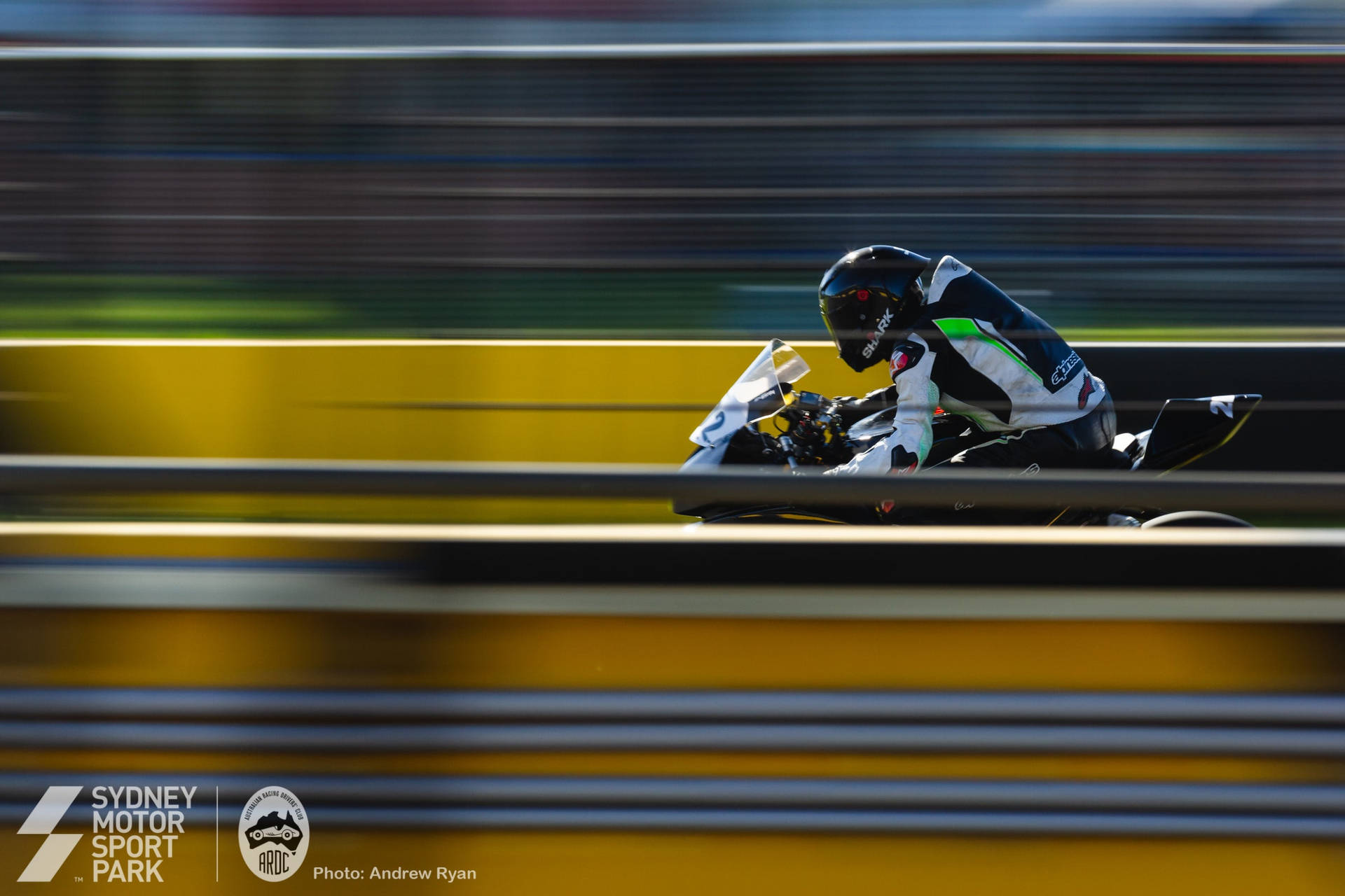 Motorcycle Rider In Sydney Motorsport Park Background