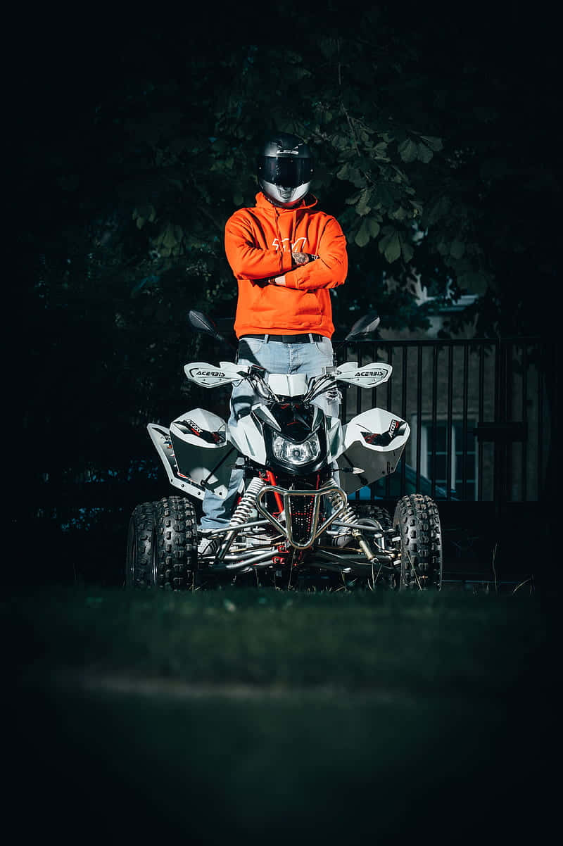 Motorcyclist Standing Behind A T V Background
