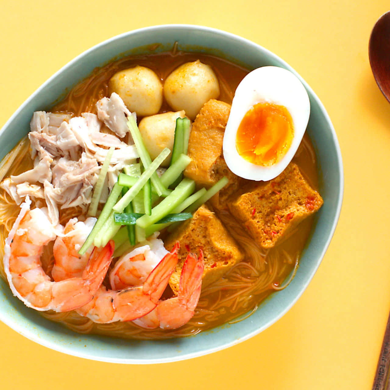 Mouthwatering Curry Laksa Served On A Bright Yellow Table