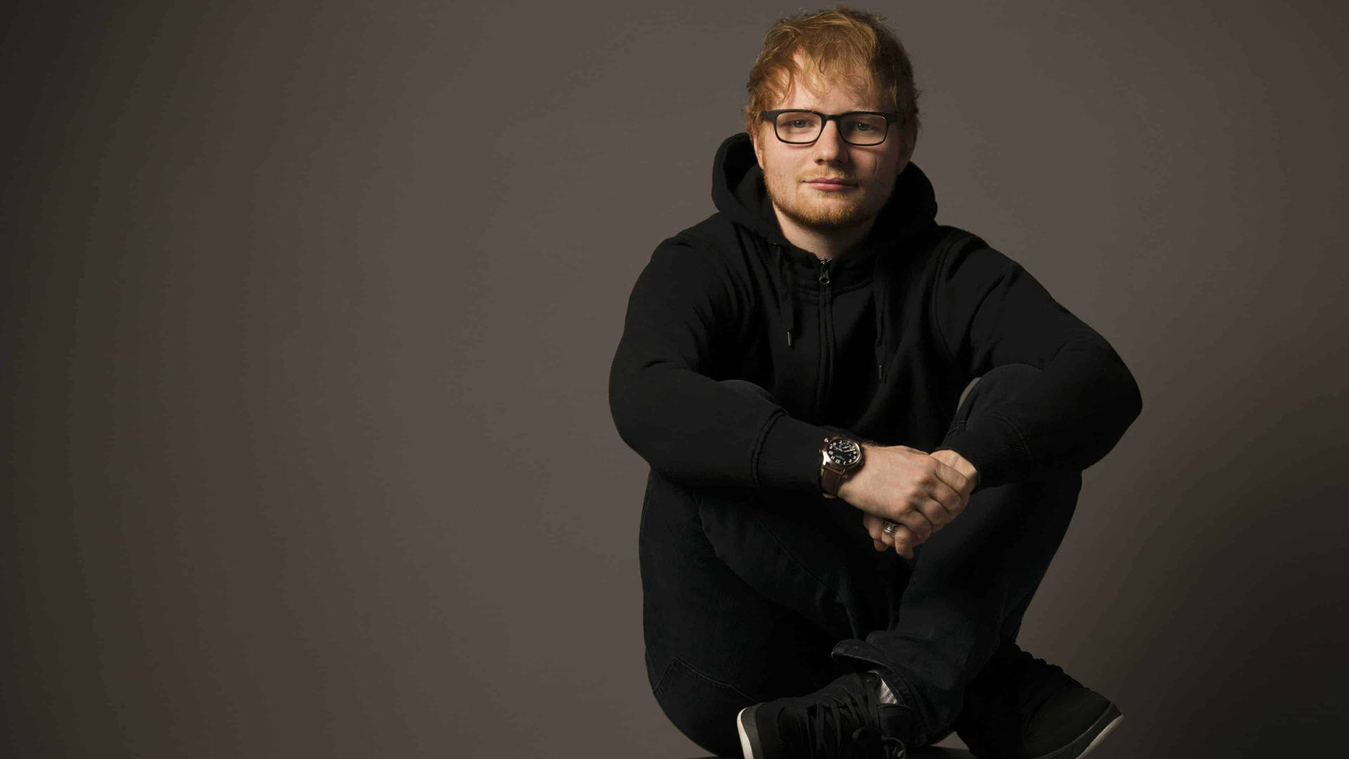 Multi-platinum Singer-songwriter Ed Sheeran In A Black Hoodie Background